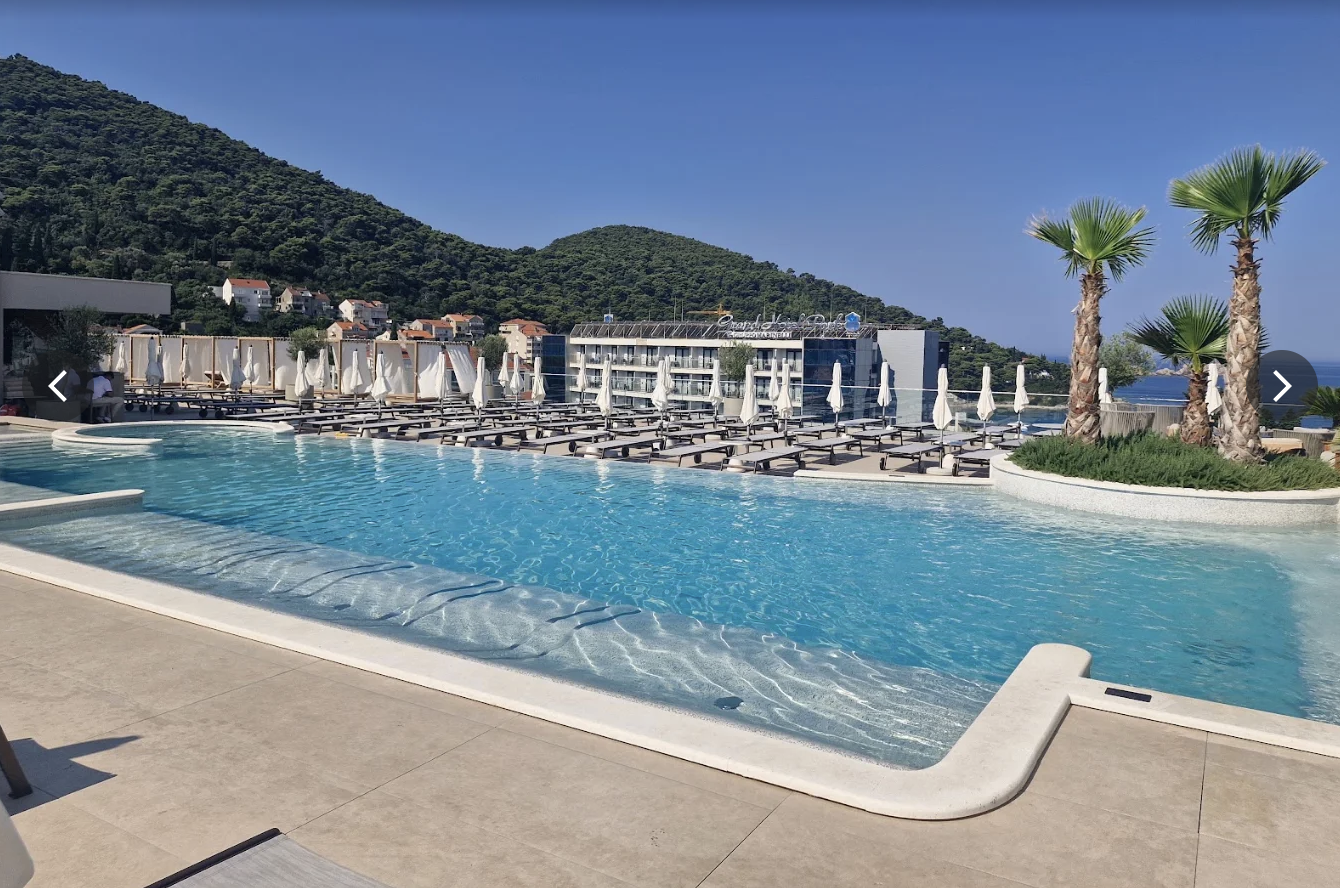 The main pool at Hotel Sumratin with the hills of Lapad behind it