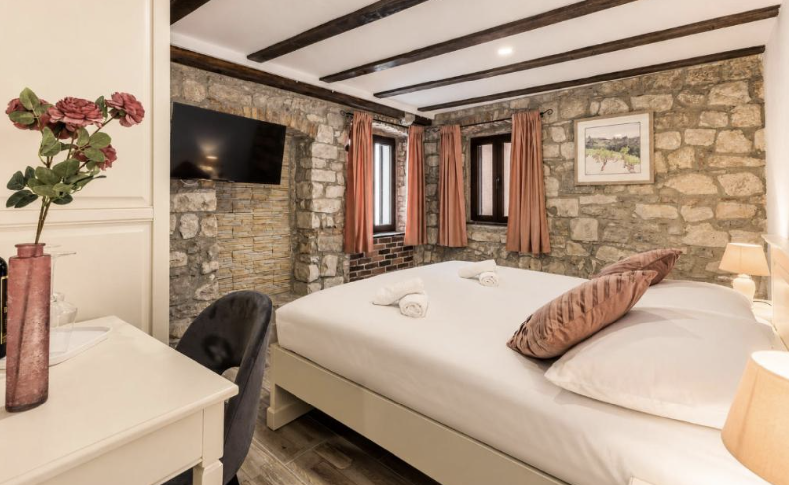 Stone-walled room with beamed ceiling and terracotta curtains
